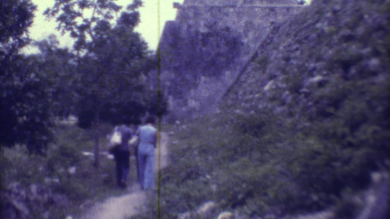 Two women walk away from the camera along a narrow path near stone ruins in Yucatan, Mexico, in 1973.