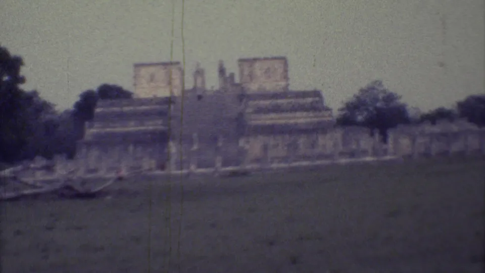 The closing 1973 Yucatan frame shows the tan stepped monument across grass, with trees and vertical posts visible nearby.