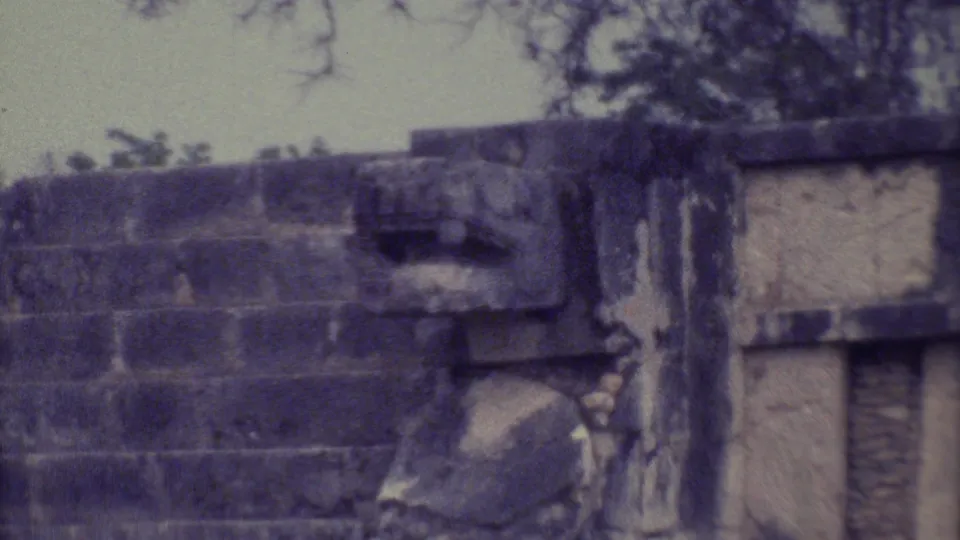 A Yucatan ruin wall, tree trunk, and weathered stonework appear in faded 1973 8mm footage.