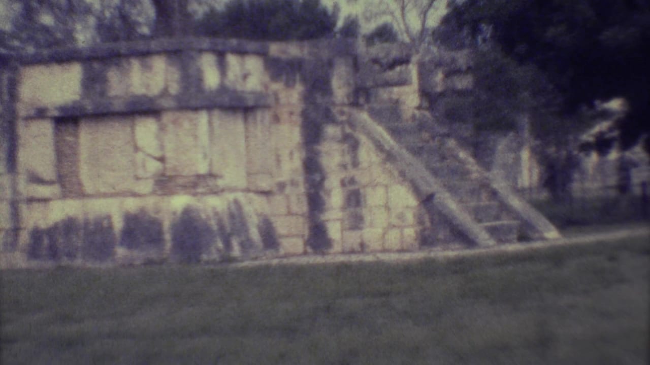 1973 Yucatan 8mm frame showing a weathered stone structure with a steep stairway, grass in front, and dense trees behind.