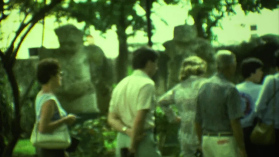 The final 1973 Yucatan frame shows adult tourists gathered near stone sculptures in a tree-filled outdoor exhibit.