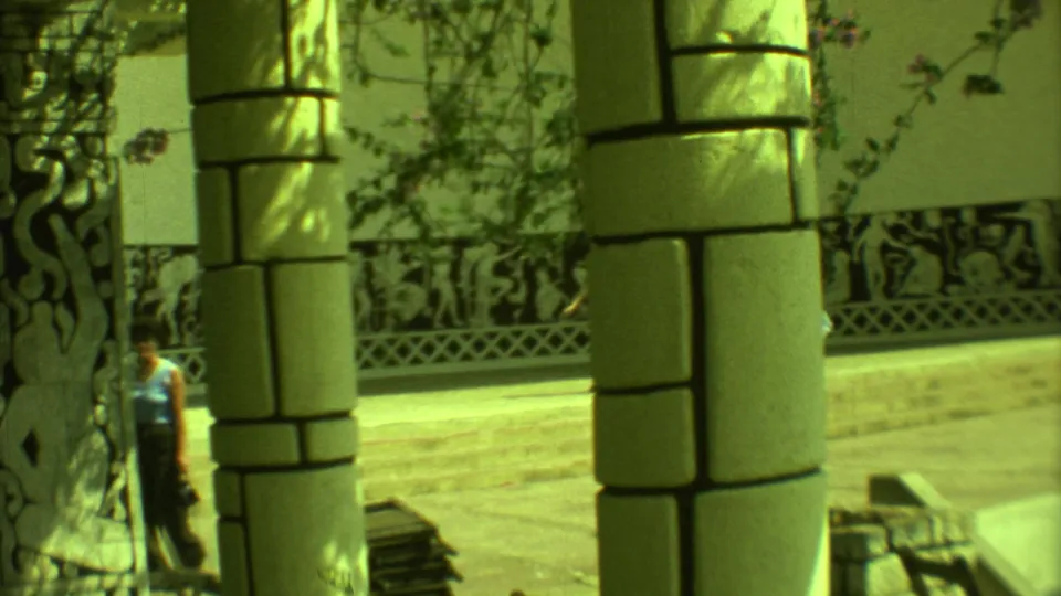 1973 Yucatan 8mm frame with foreground stone columns, vines, and Mayan-style decorative wall panels at a public site.