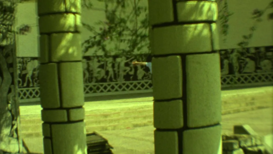 1973 Yucatan 8mm frame focused on stone columns, patterned wall panels, and bright pavement at a cultural public site.