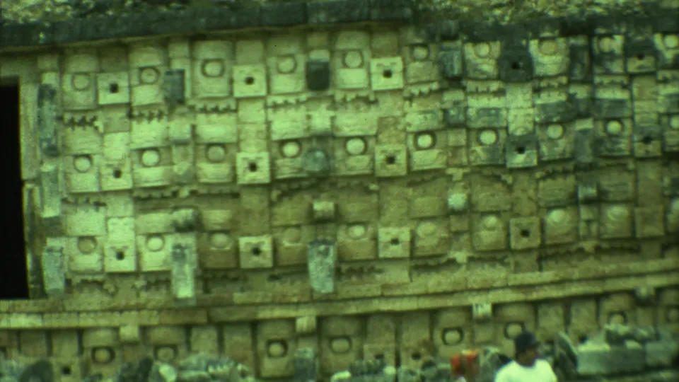 1973 Yucatan travel footage showing a close view of carved stone blocks at an archaeological ruin site.