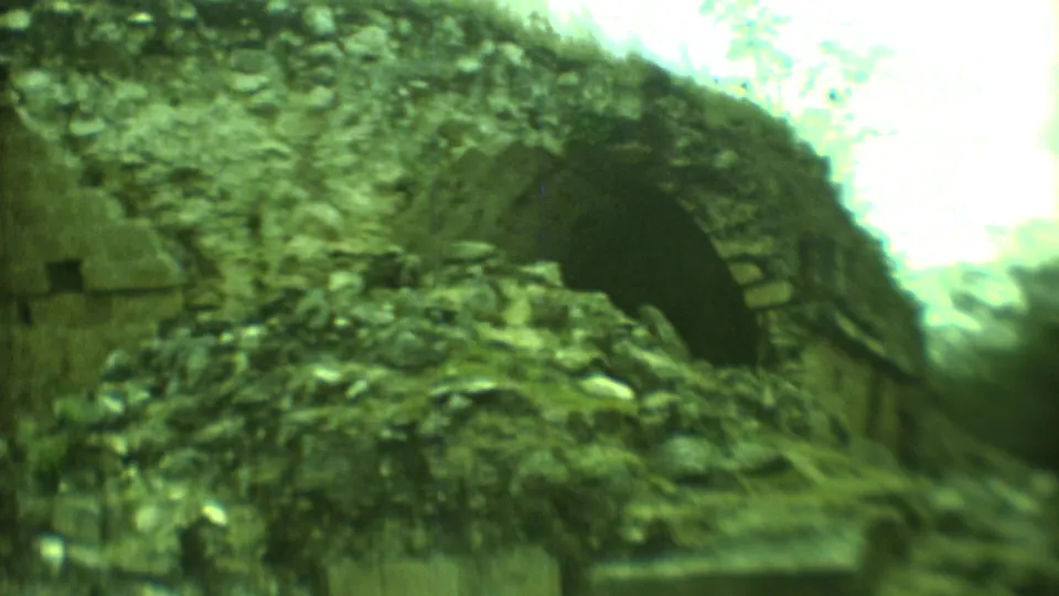 1973 Yucatan 8mm frame showing a weathered stone arch set into a crumbling ruin with green-tinted film color.