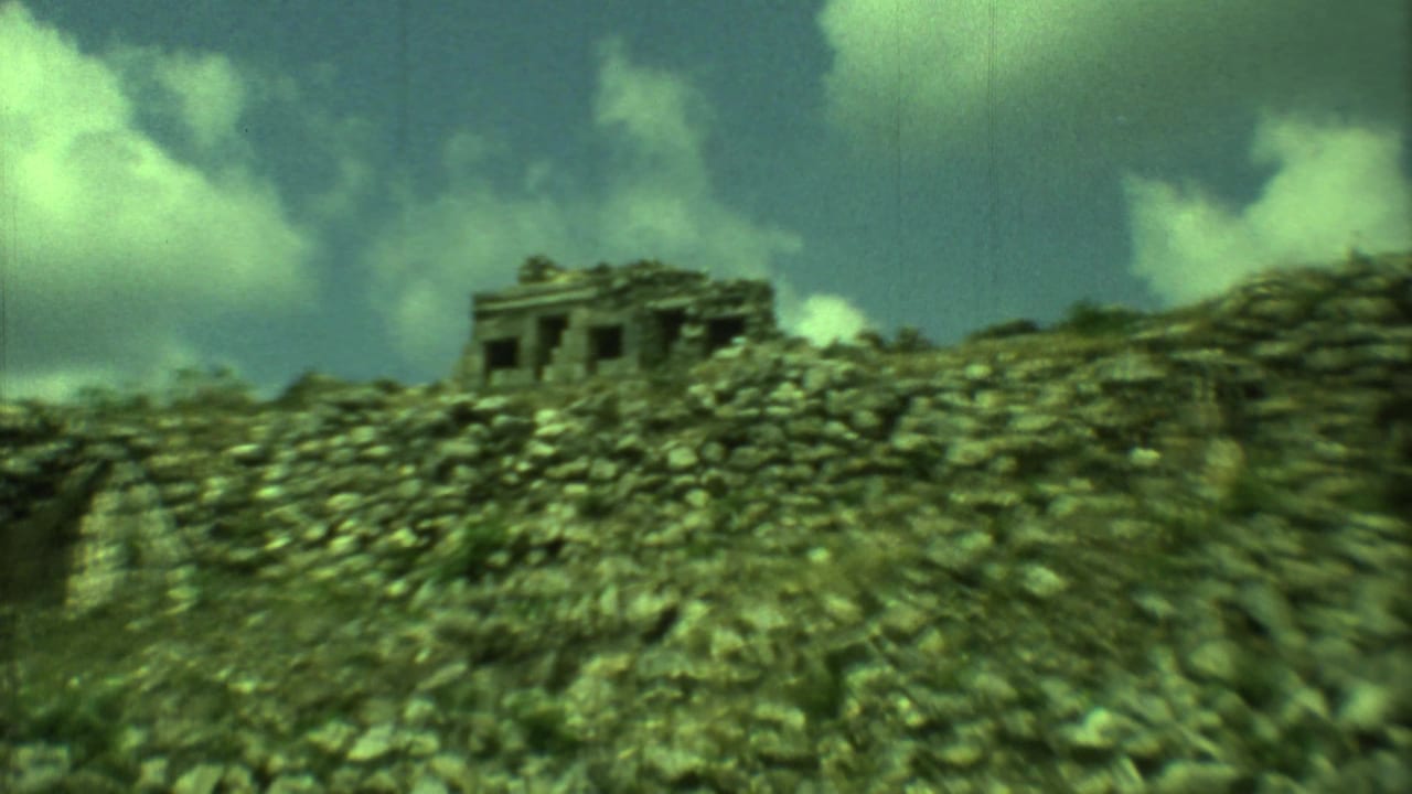 Stone ruin on a rocky hill under clouds, seen through green-tinted 8mm film.