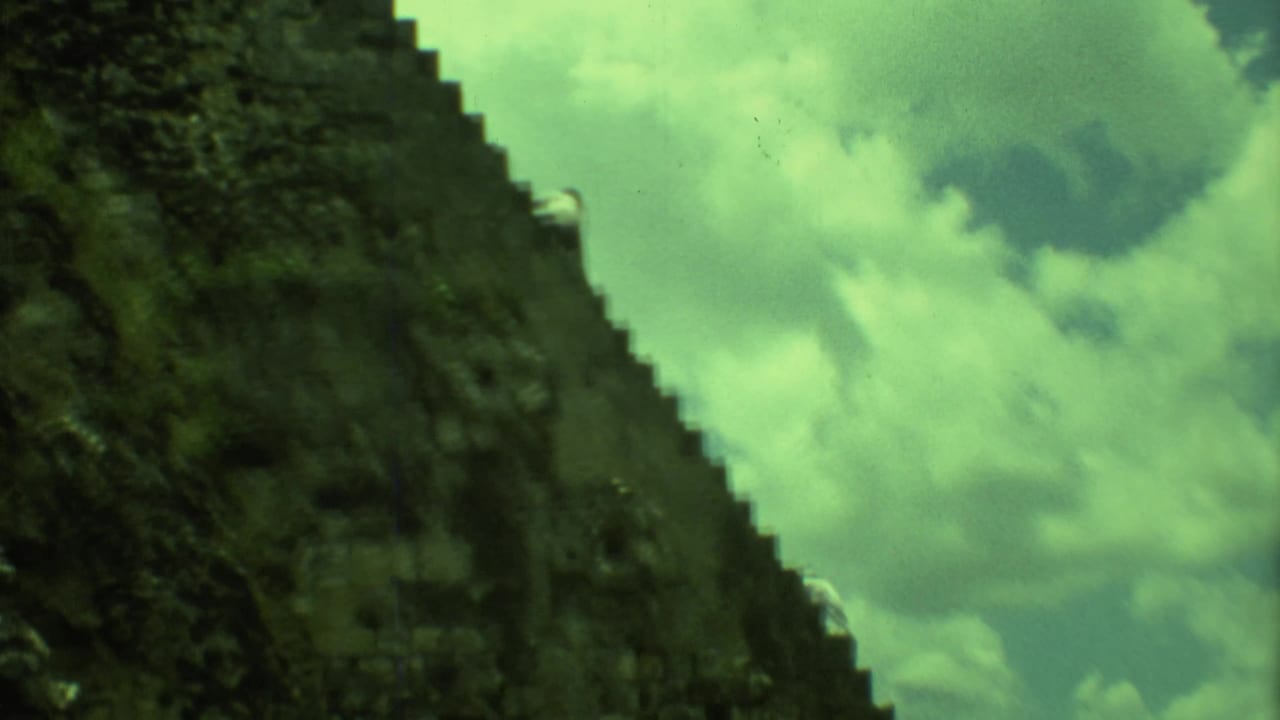 Low-angle view of steep stone pyramid stairs against clouds and green-tinted sky.