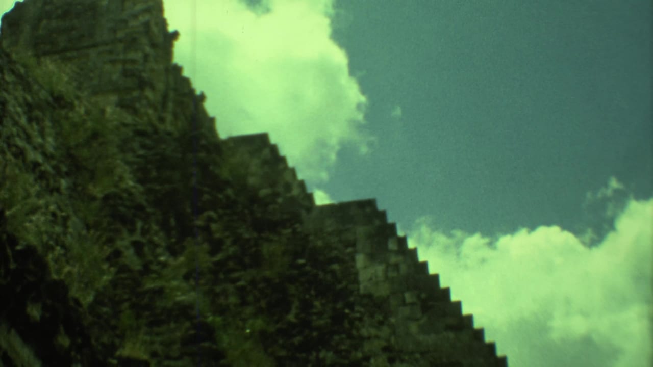 Stone steps and dark ruin edge under a bright cloudy sky.