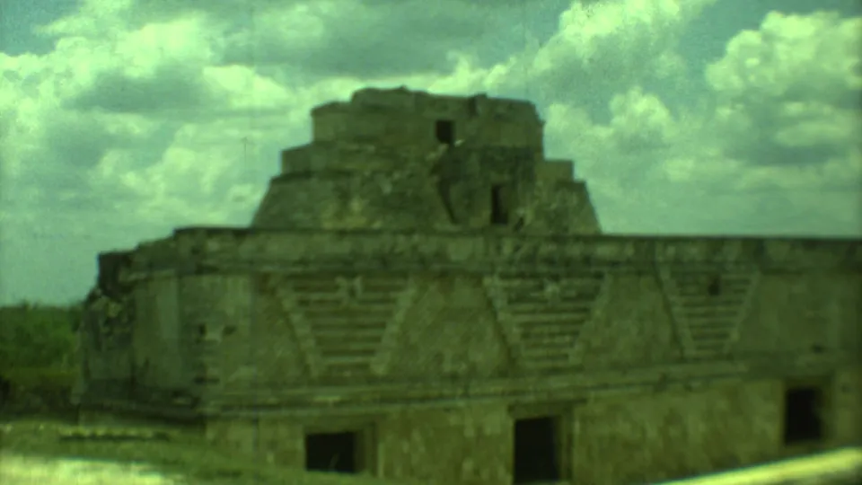1973 Yucatan 8mm frame showing a stepped Maya stone structure with patterned facade details and dark openings.