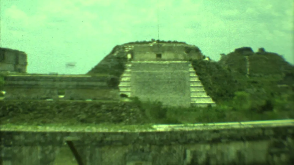 Closer 1973 Yucatan 8mm view of a stepped stone ruin, adjacent masonry, and vegetation at an archaeological site.
