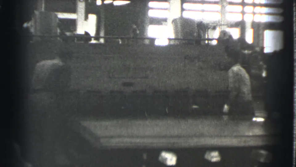 A worker stands near the machine in the Cleveland factory, with another person partly visible at the edge of the frame.