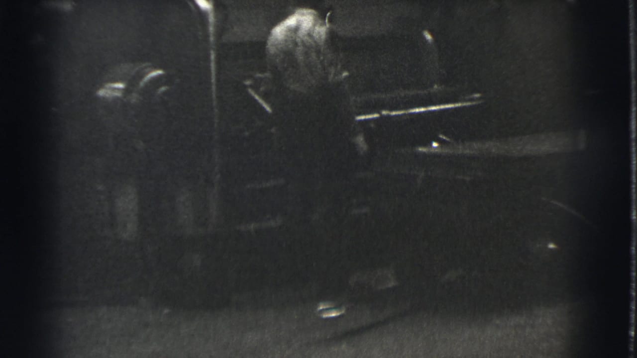 In 1939 Cleveland footage, a man appears beside large industrial machinery in a shadowed black-and-white factory setting.
