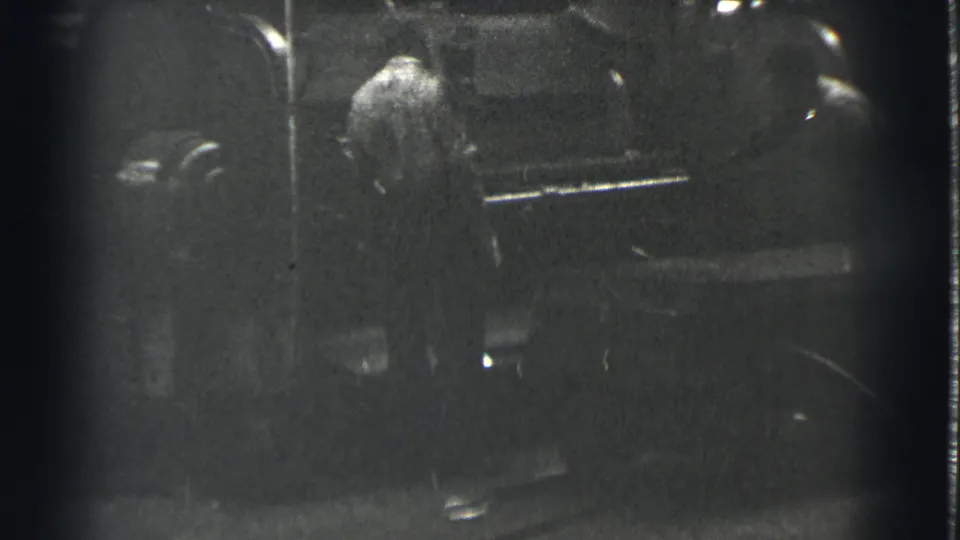 The final frame holds on a man near machinery in the same 1939 Cleveland industrial interior, with strong grain and dark exposure.