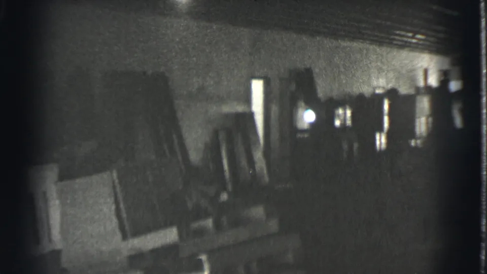 1939 Cleveland footage appears to show a dim warehouse, factory, or garage interior with stacked materials and hard light in the distance.
