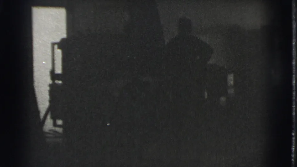 The final frame is a heavily shadowed Cleveland industrial or storage interior with a bright vertical opening and obscured figures or equipment.