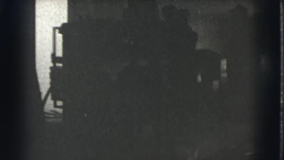 This closing 1939 Cleveland frame shows barely defined people in a shadowy room, with a bright opening at the left edge.