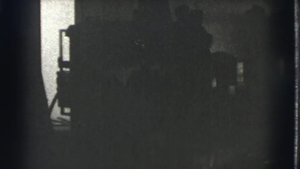 Dark opening frame from a 1939 Cleveland 8mm clip, with only a partial building edge and shadowed exterior shapes visible.