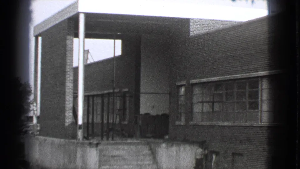 1939 Cleveland factory exterior showing a covered brick entrance, concrete steps, and rows of industrial windows.
