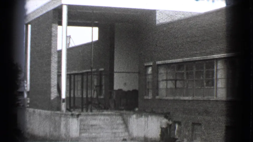 Cleveland factory exterior in 1939, with a covered entry bay, concrete steps, brick walls, and industrial windows.