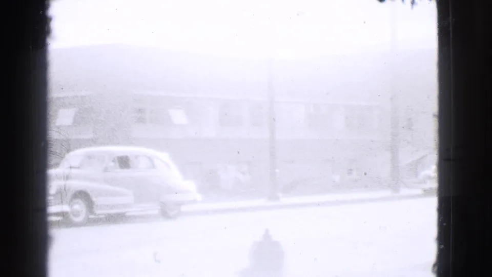 Faded 1939 Cleveland street view with parked automobiles, a curbside fire hydrant, and a low building in the background.