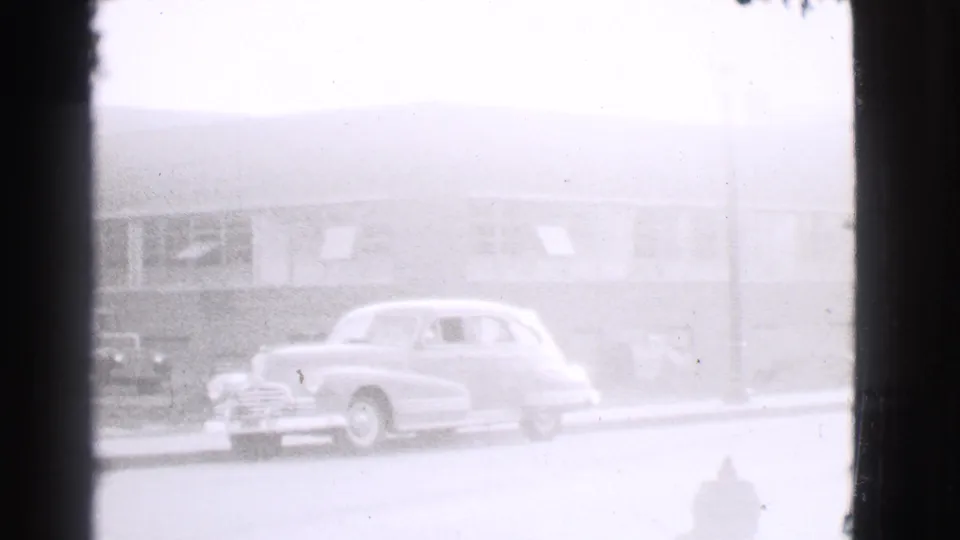 1939 Cleveland frame showing a light-colored parked car, fire hydrant, and low building facade through soft 8mm exposure.