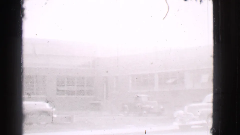 1939 Cleveland building frontage with a small truck and partial views of parked cars along the street.