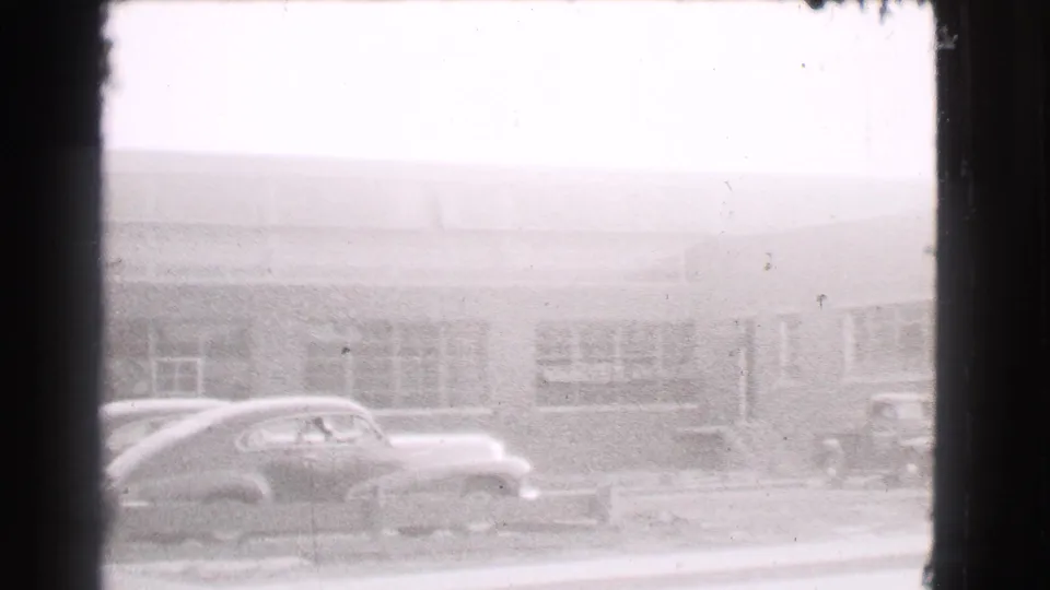 A late-1930s rounded sedan appears curbside in Cleveland, with a low commercial-looking building behind it.