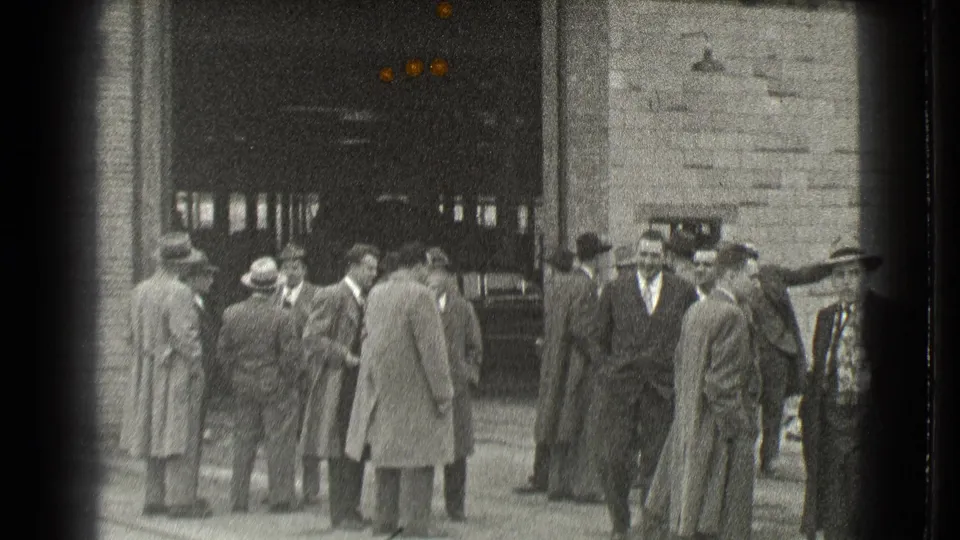 The final frame shows suited men in hats gathered outside a Cleveland building, with a car partly visible at right.