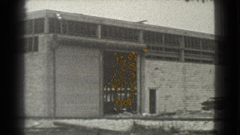 1939 Cleveland 8mm frame showing a long industrial facade with an open garage-style doorway and upper window band.
