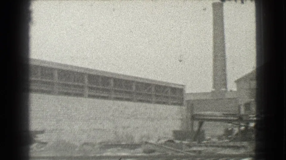 1939 Cleveland frame with a long warehouse-like wall, upper window band, and a tall smokestack near the edge.