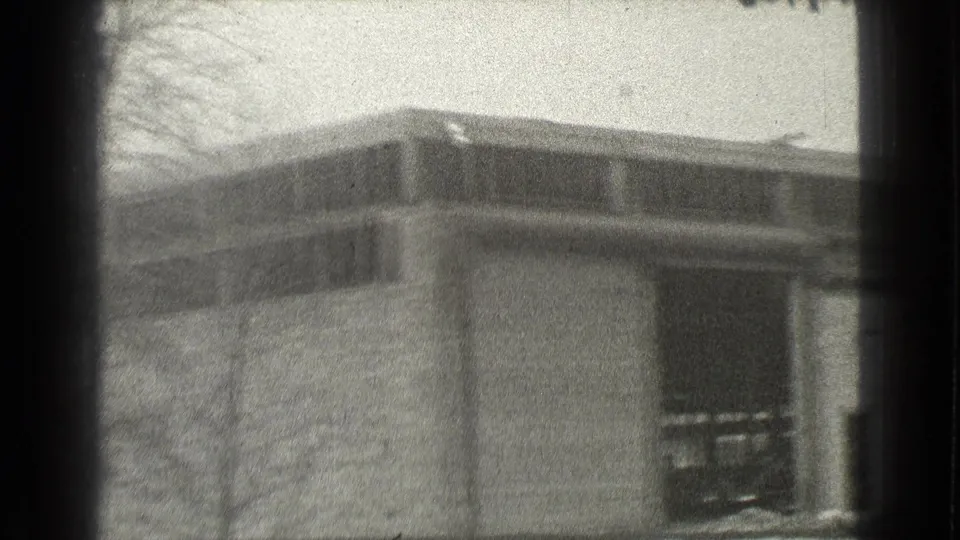 1939 Cleveland frame showing the corner of an industrial or commercial building with broad upper windows and a leafless tree.
