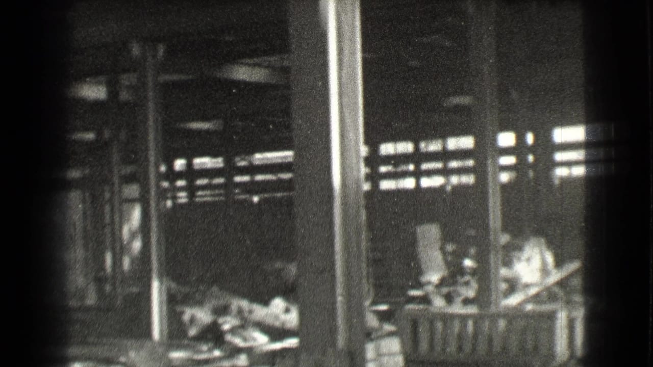 Dim industrial room with columns, high slatted windows, and scattered material on the floor.