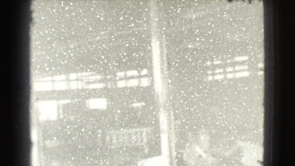 Final 1939 Cleveland frame shows the factory-like room in heavy exposure, with posts, window bands, and scattered low forms.