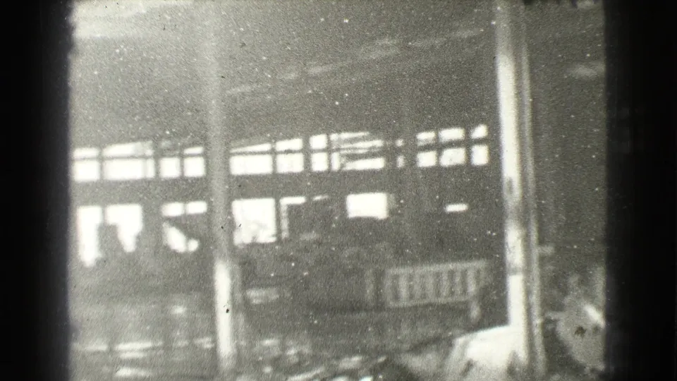 Faded 8mm frame from the Cleveland clip showing tall building windows, columns, and indistinct sidewalk detail.