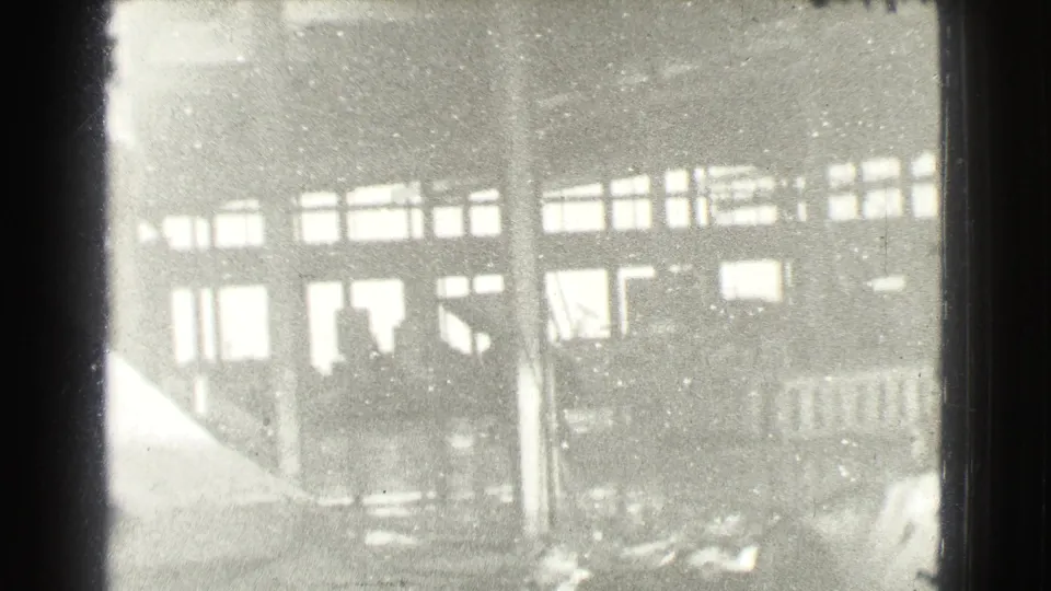 Faded 8mm frame from the 1939 Cleveland metadata showing a large building facade, windows, columns, and blurred street-level detail.