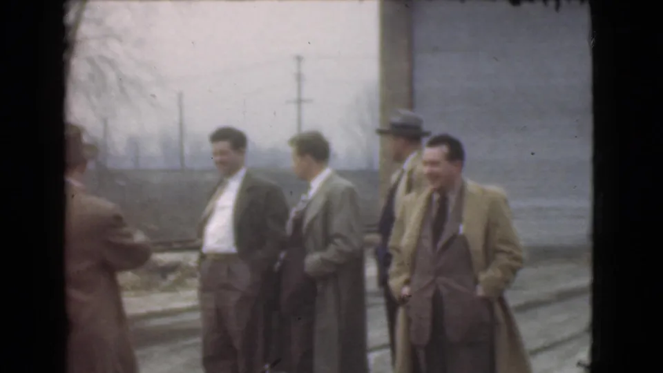The final frame shows five men in coats and suits on a Cleveland street, plus a partial figure at the left edge.