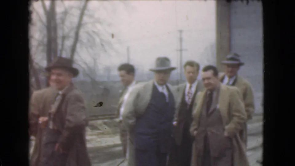 Adult men in suits, overcoats, and fedoras gather outdoors in Cleveland, Ohio, in 1939 home-movie footage.