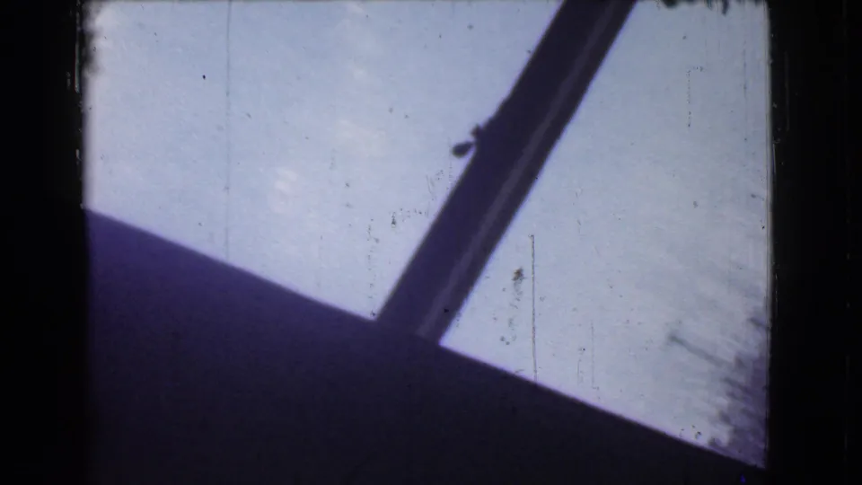 Opening 1939 Cleveland 8mm frame with dark borders and a slanted foreground edge against a pale snowy outdoor view.