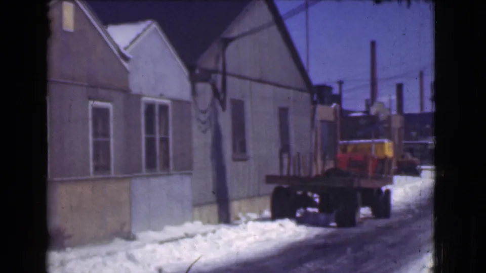 1939 Cleveland snowy residential street with frame houses, overhead wires, snowbanks, and a parked flatbed truck in view.