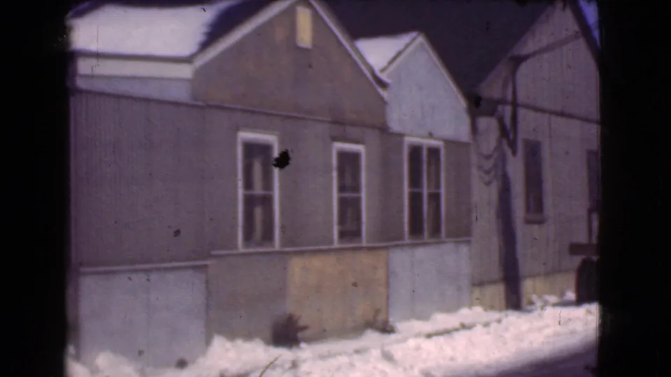 1939 Cleveland 8mm frame showing a modest brown house with white-trimmed windows and snowbanks along the base.