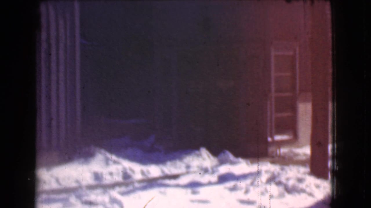 Dark storefront wall and door partly obscured by snow along the base.