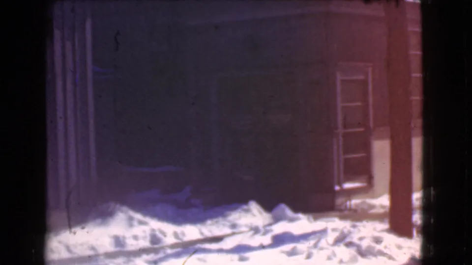 1939 Cleveland exterior frame with heavy snow along a storefront base and a partially visible doorway.