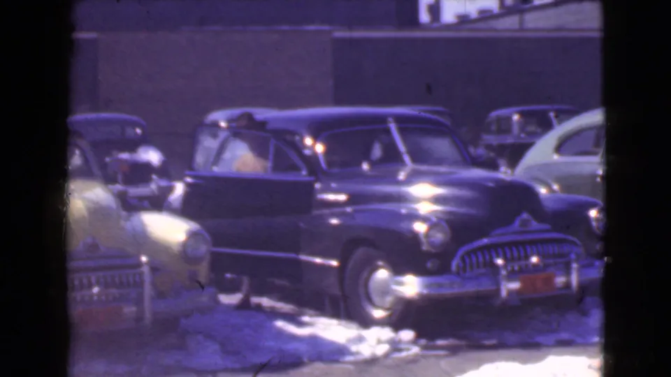 1939 Cleveland street view with a dark limousine-like car, snow on the ground, and several parked period automobiles.