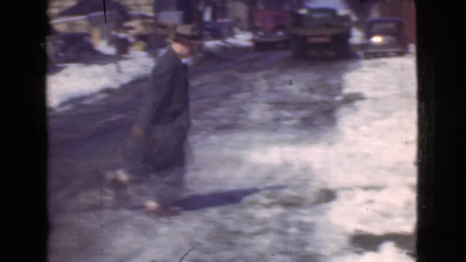 The same adult man moves through a slushy Cleveland street scene, with snowbanks, parked cars, and a winter residential block visible.