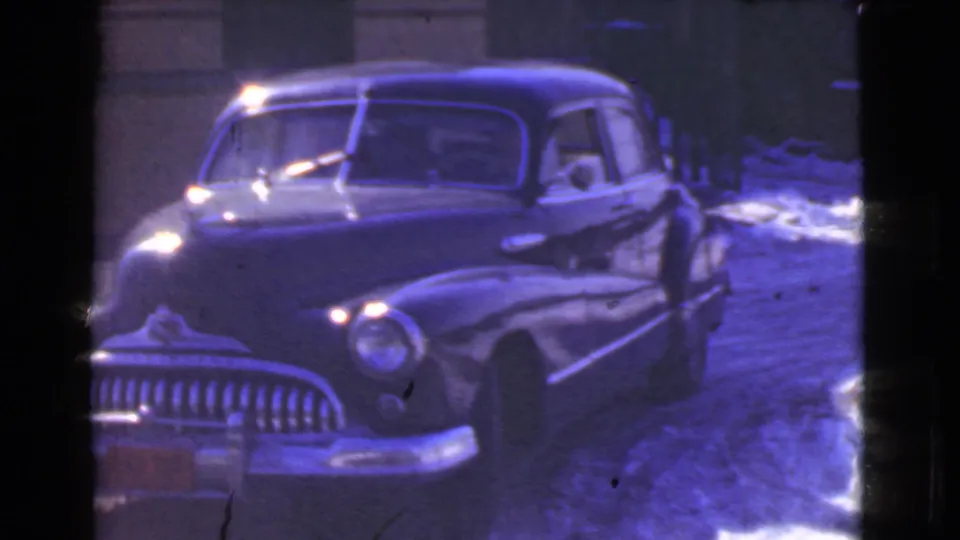 A closer 1939 Cleveland view shows the dark sedan angled near the snowy curb, with reflected highlights across its hood and windshield.