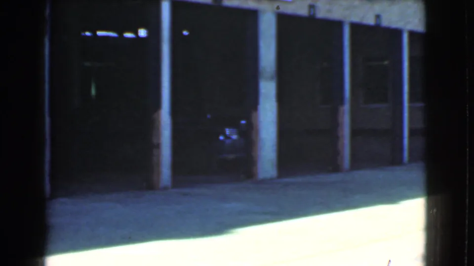 1939 Cleveland home-movie frame of shadowed loading dock entrances with a partial freight truck edge visible at right.