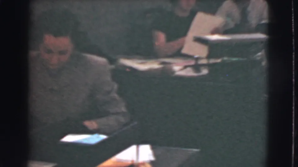 1939 Cleveland office scene showing a seated man near a desk while workers behind him handle papers at nearby workstations.
