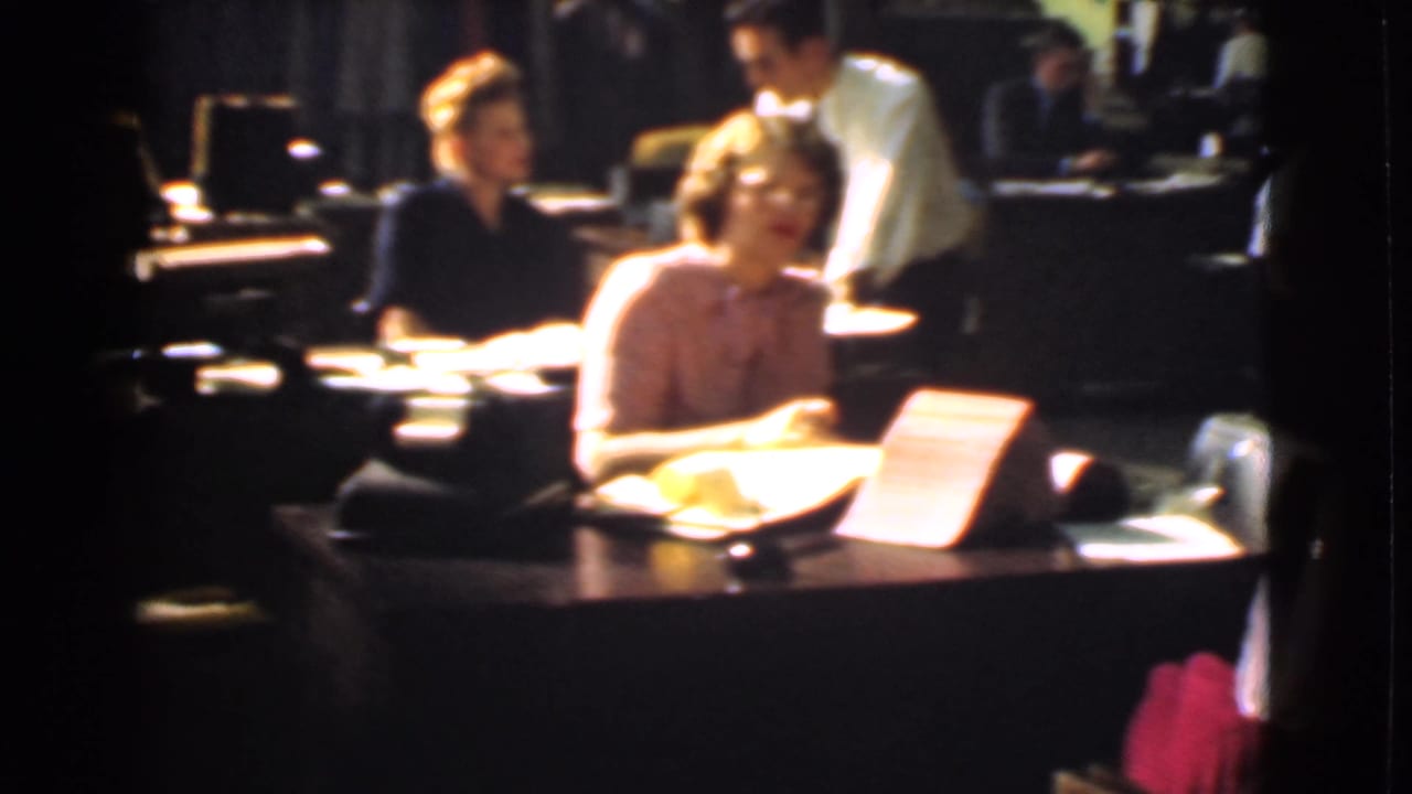 1939 Cleveland office interior with workers at wooden desks, paperwork, and warm 8mm film color.