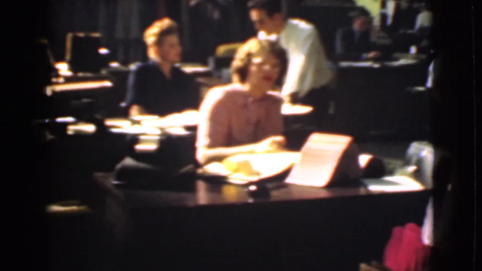 1939 Cleveland office interior with workers at wooden desks, paperwork, and warm 8mm film color.