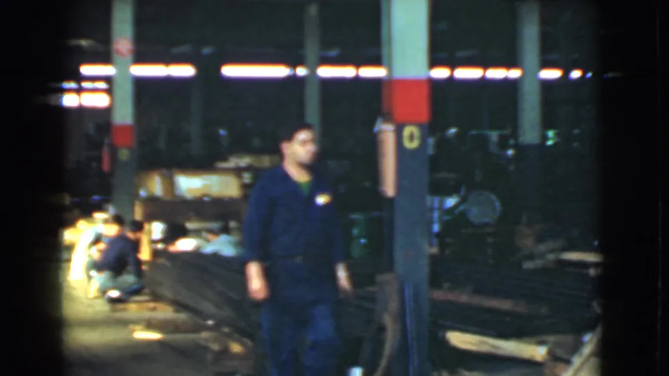 The Cleveland warehouse scene shows a uniformed worker near a support column, with two other workers lower to the floor near materials and equipment.